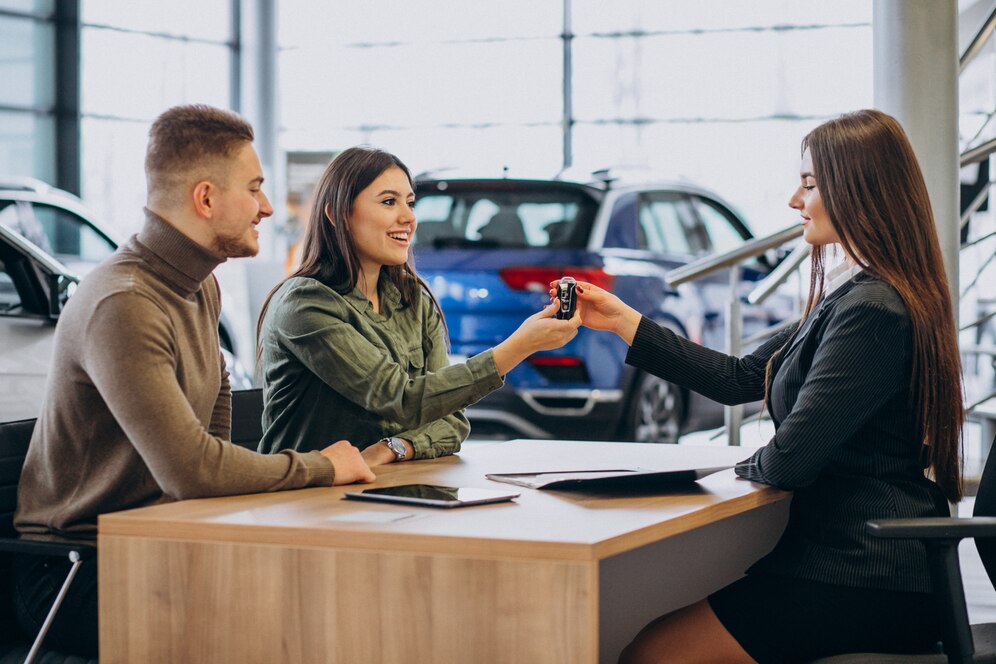 Small car dealership manager using accounting software on a laptop, emphasizing the importance of dealership accounting tools for financial management and growth.