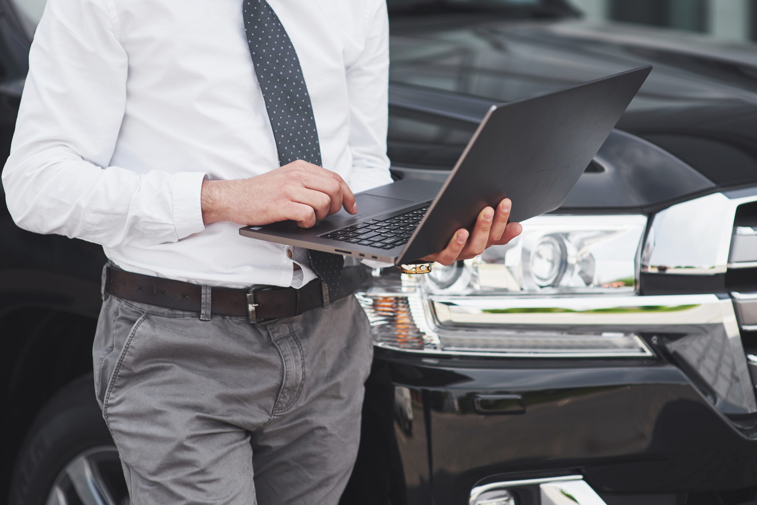 man working with his laptop related to car dealers and management system